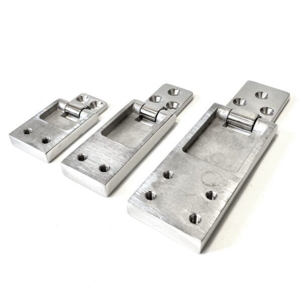 Three different sized stainless steel flush hinges placed next to each other.